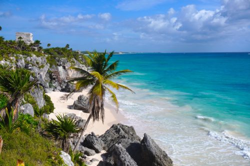 La plage située directement en contrebas des ruines de Tulum, avec la mer turquoise et la falaise